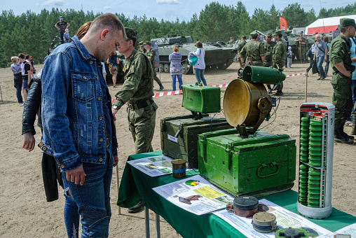 Tyumen, Russia - June 11, 2016: Race of Heroes project on the ground of the highest military and engineering school. Exhibition of weapon. Man - visitor of show examines samples at stand with mines