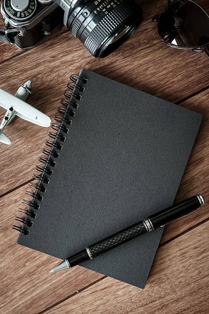 istock Retro camera with black notebook on wooden background 611766090