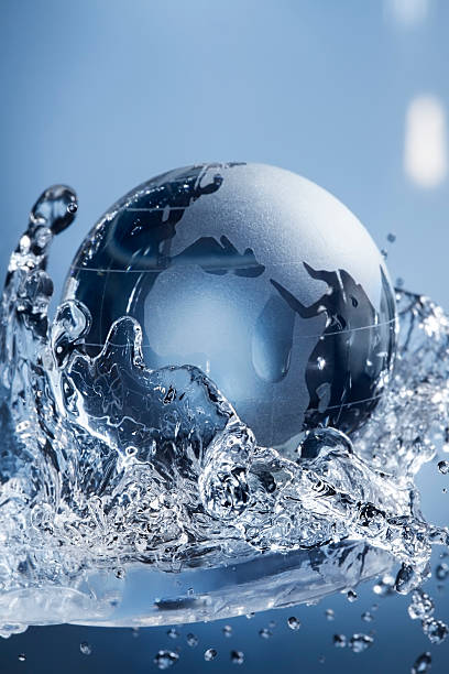 glass globe planet in drop water splash on blue background