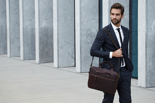 Businessman with briefcase walking in city