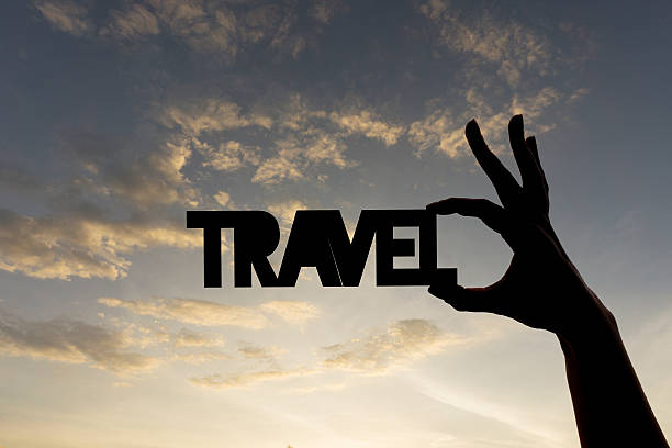 istock Travel word being held against sky 611768628