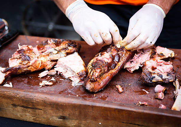 istock Hands cleaning Grilled spare beef or pork ribs from smoker. 611772324