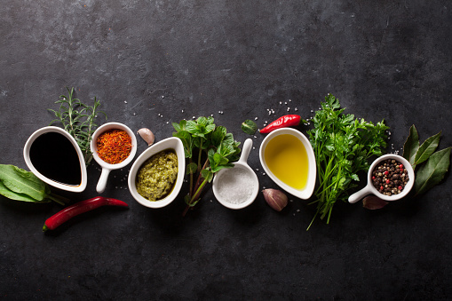 Herbs, condiments and spices on stone background. Top view with copy space