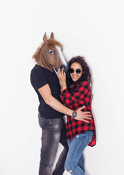 ritratto di ragazza bella e felice e il suo fidanzato testa di cavallo - horse men animal head bizarre foto e immagini stock