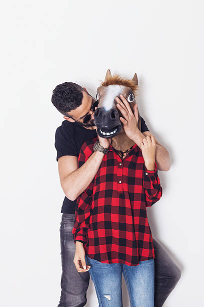 ritratto uomo che gioca a nascondino con la fidanzata testa di cavallo - horse men animal head bizarre foto e immagini stock