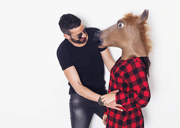 ritratto uomo ridente scherzando con la sua ragazza testa di cavallo - horse men animal head bizarre foto e immagini stock