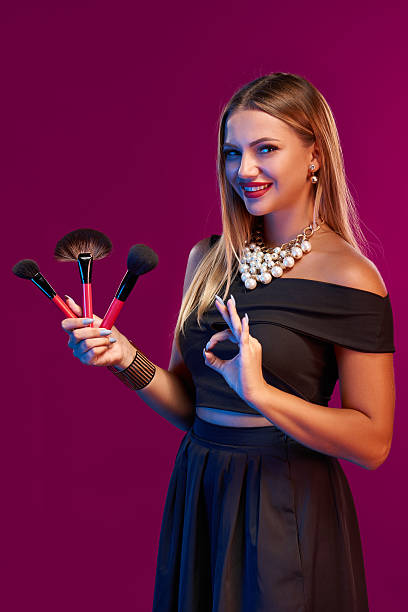 istock Woman makeup artist standing with brushes 611774744