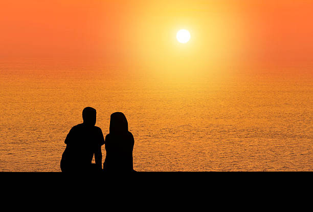 istock silhoutte rear view romantic couple sit relax watching sunset 611775816