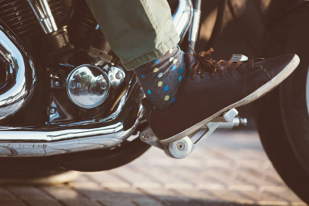 istock Motorbiker in leather shoe on throttle pedal 611780932