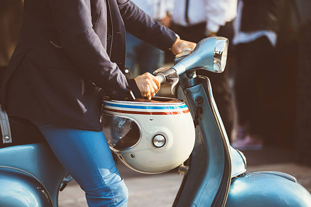 Close-up of unrecognizable person in jacket sitting on retro blue bike with vintage helmet
