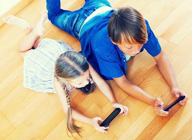 istock Positive siblings playing with phones 611782208