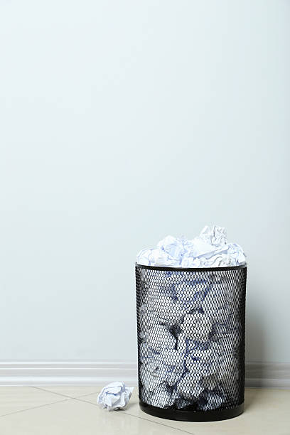 istock Office trashcan with crumpled paper balls on grey background 611783112