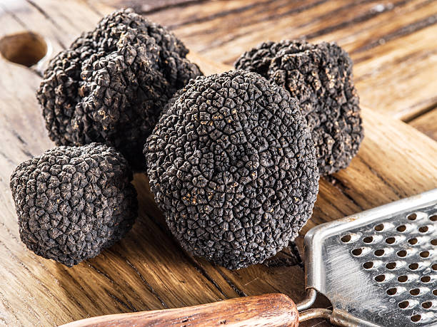 istock Black truffles on the old wooden table. 611783992