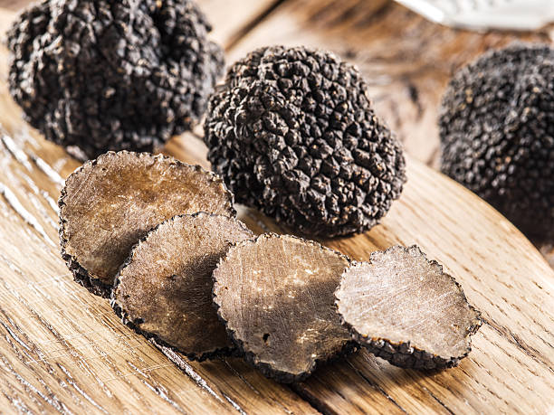 istock Black truffles on the old wooden table. 611784018