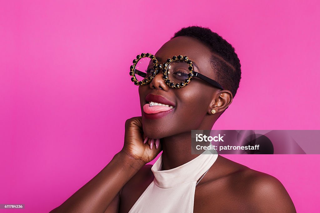 Drôle de fille africaine avec la langue est sortie portant des lunettes étranges - Photo de Bizarre libre de droits