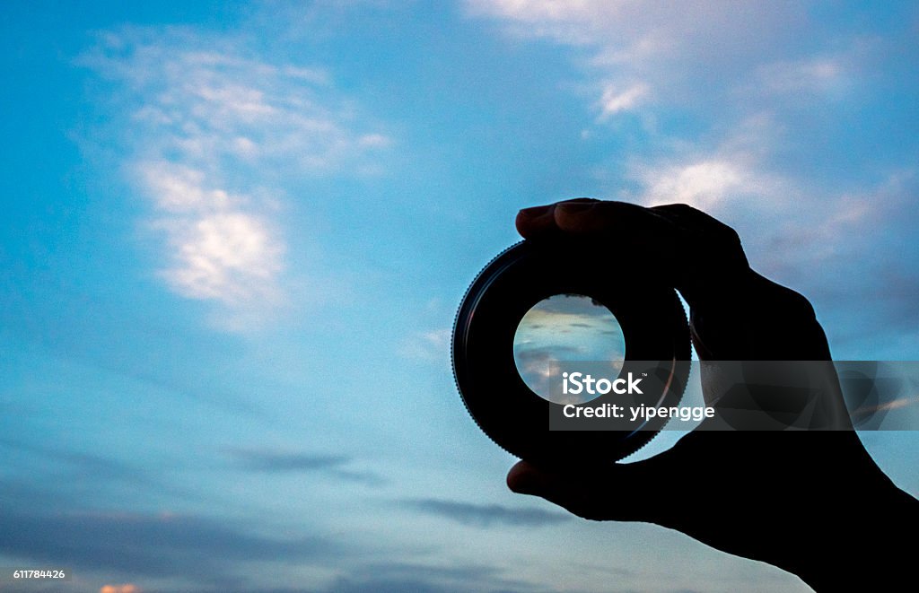 hand holding lens watching cloudscape Telescope Stock Photo