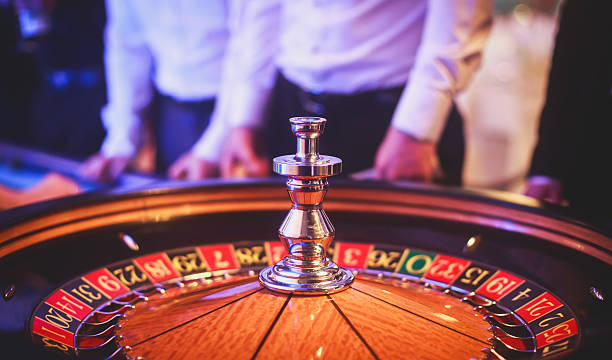 яркий образ разноцветного стола казино, люди на заднем плане - casino roulette gambling casino worker стоковые фото и изображения