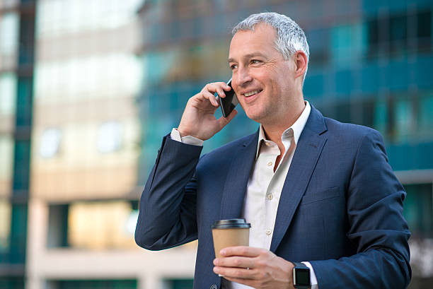 istock professional businessman using smartphone  and holding coffee to 611786498