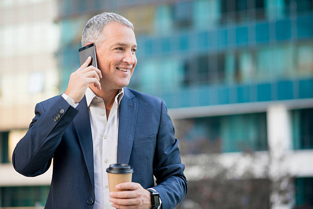 istock professional businessman using smartphone  and holding coffee to 611786582