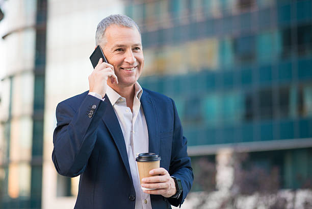 istock professional businessman using smartphone  and holding coffee to 611786658