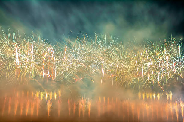 Colorful firework display Beautiful firework display in red, orange green, and white with a lot of smoke around hogmanay photos stock pictures, royalty-free photos & images