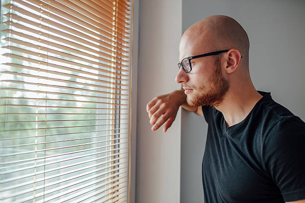 istock Young man is looking out the window. 611788540