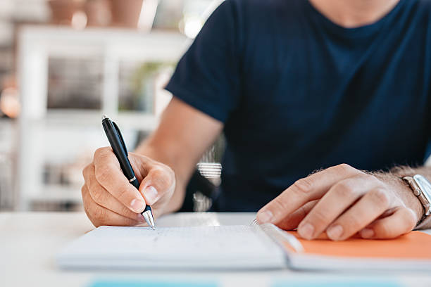 istock Hands of a young man writing in a office diary 611790696