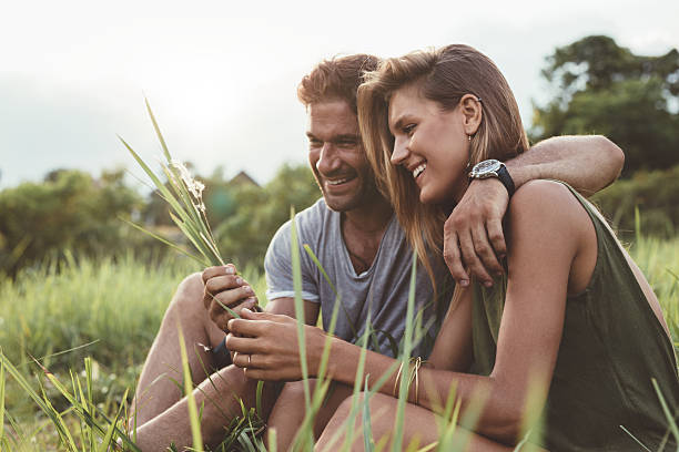 istock Smiling young couple sitting together outdoor 611856536