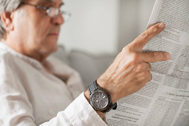 istock Senior man reading newspaper in home 611857156