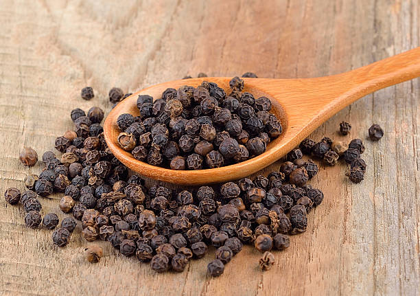 istock Black pepper corn on wooden scoop 611859146