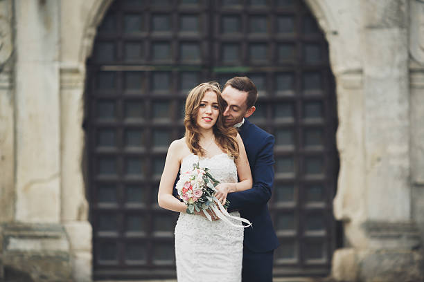 istock Happy wedding couple hugging and smiling each other on background 611860726