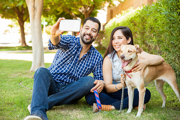счастливая семья с собакой, беруей селфи - vacations photographing brown hair 30s стоковые фото и изображения