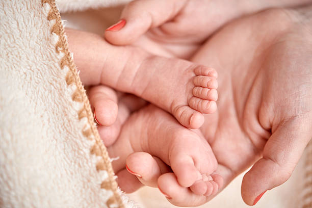istock baby boy feet in mother hands 611862414