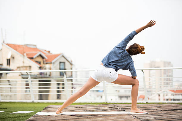 istock Beautiful woman doing yoga outdoors on a rooftop terrace 611862448