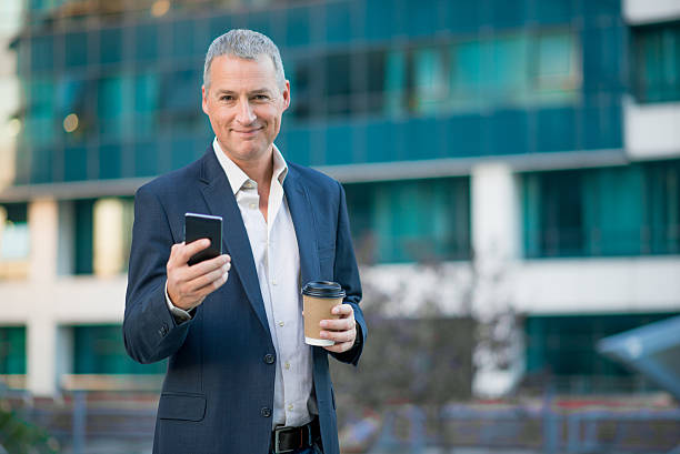 istock businessman having coffee break holding coffee to go outside 611862924