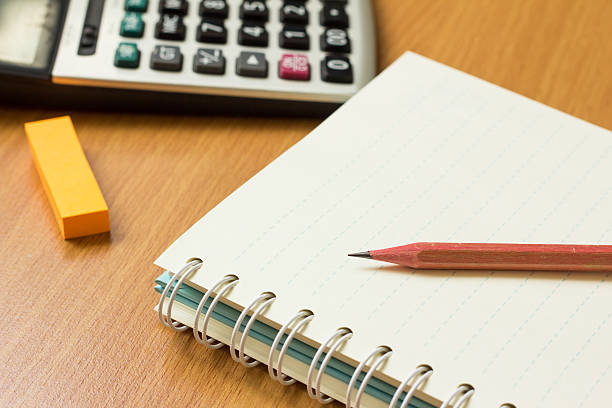 istock Orange note paper, pencil, book on wood table 611863714