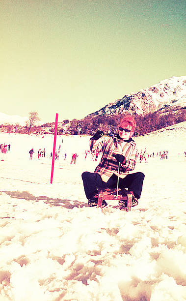 Vintage photo of a woman having fun in a snow sled