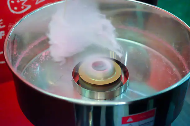 Chef making pink cotton candy in cotton candy machine