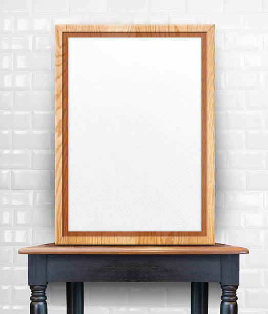 istock Blank wooden photo frame leaning at tile wall on table 611866102