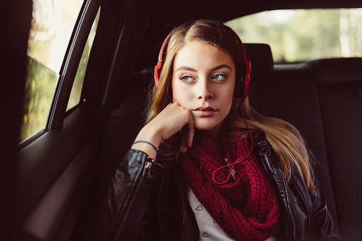 Woman traveling in car and listening to music