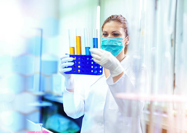 istock Woman researcher examining liquids and solutions in laboratory 611868366