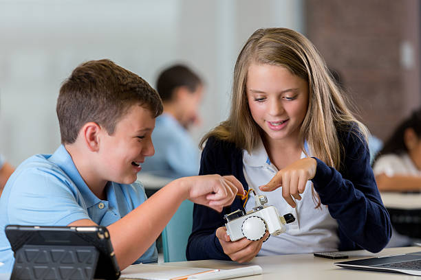 istock Teenage students build robot together in engineering class 611869884