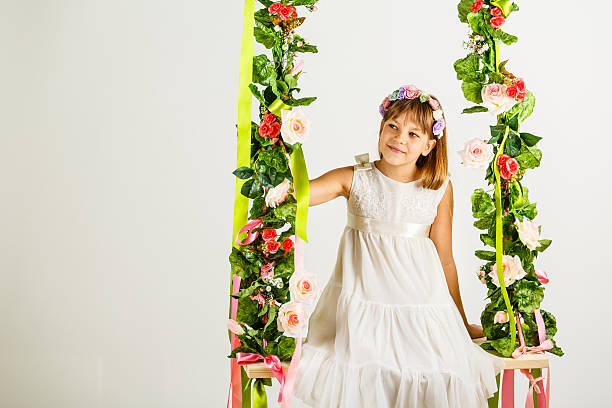 istock Girl with flower headband on swing 611870794