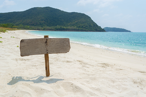 wooden signboard on tropical beach