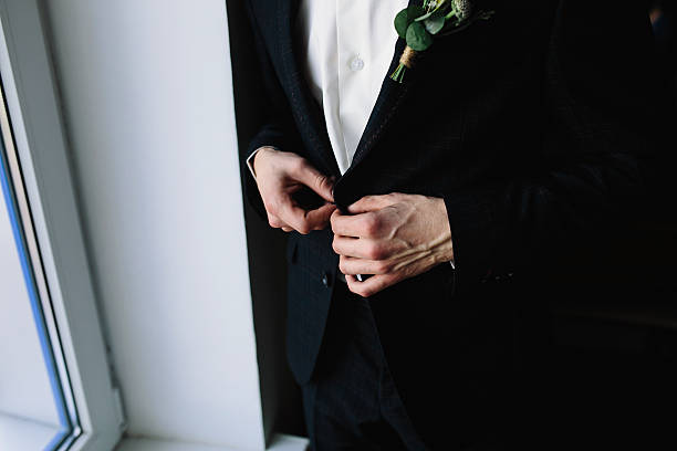 istock groom standing at the window 611875248