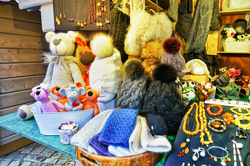 Riga, Latvia - December 25, 2015: Handmade animal toys, woolen hats and accessories displayed for sale at one of the stalls during the Christmas market in Riga, Latvia.