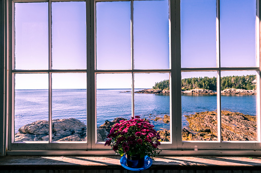 Looking through rustic windowpanes in Maine with a view of the ocean
