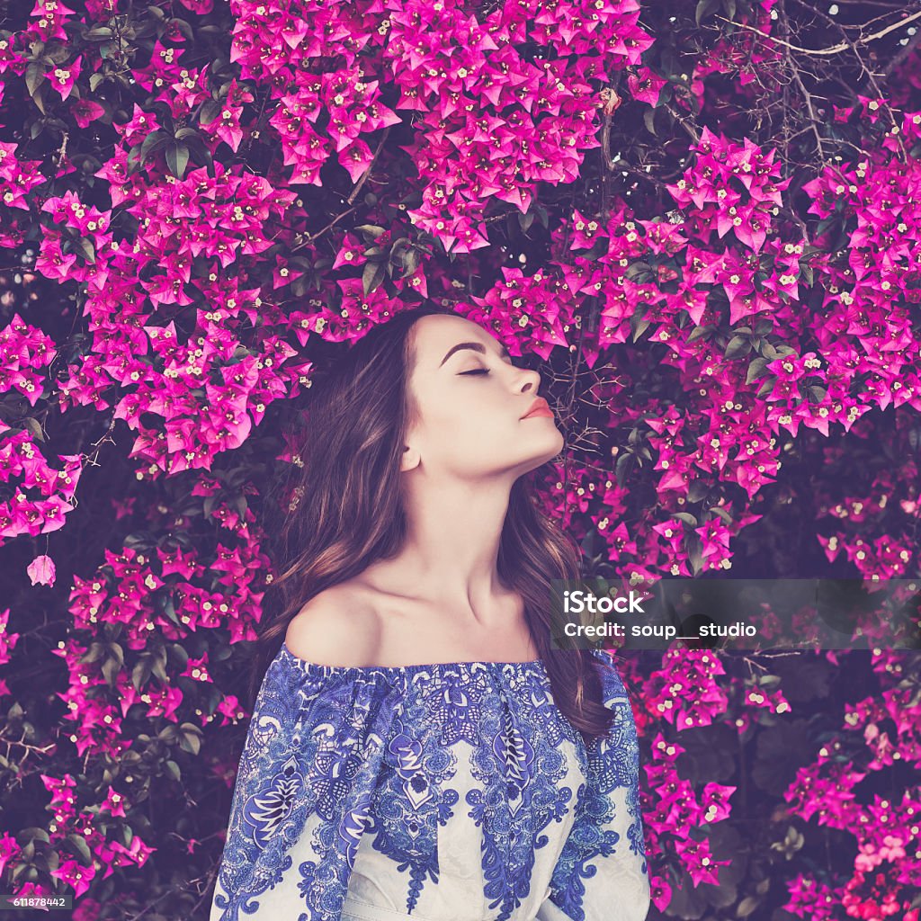 Beautiful young woman surrounded by flowers Outdoor fashion photo of beautiful young woman surrounded by flowers Females Stock Photo