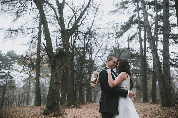 istock happy bride and groom posing in the autumn forest 611878680