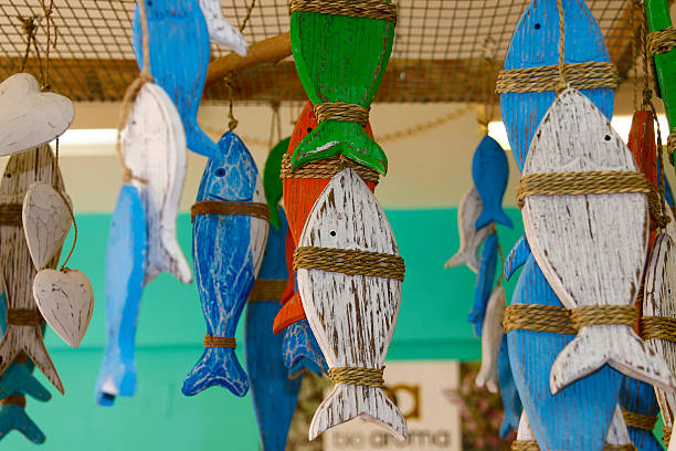 istock Multi-colored wooden fish hanging from the ceiling 611880952